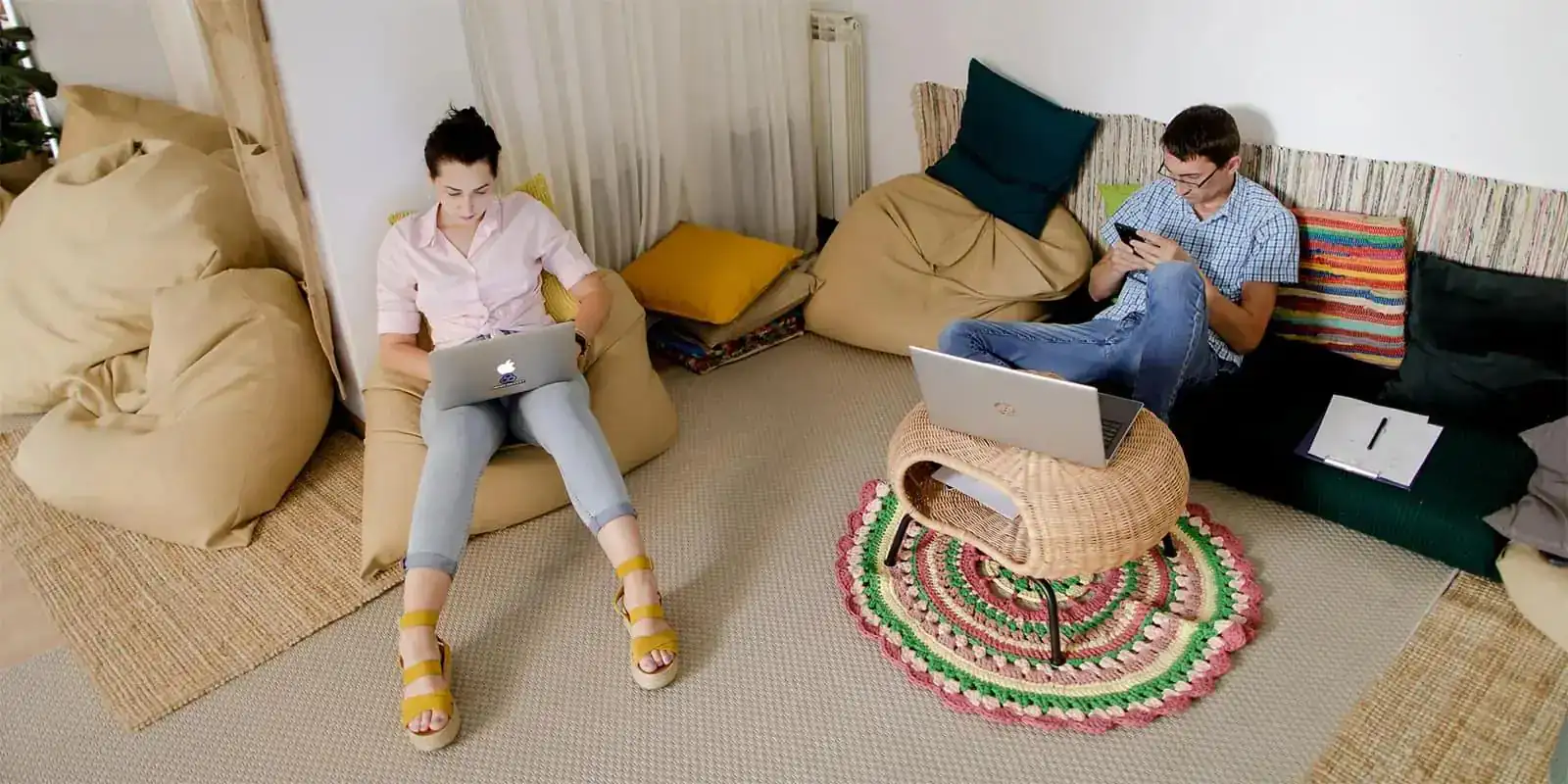 Photo of people working while relaxing on cushions and sofas